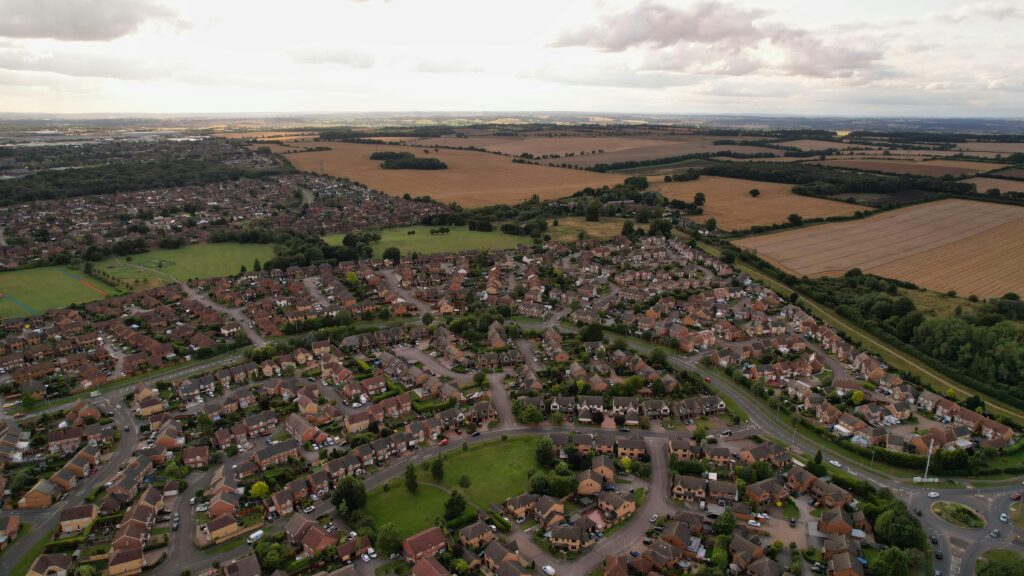 A sprawling residential area in Luton, England, surrounded by fields under a cloudy sky.